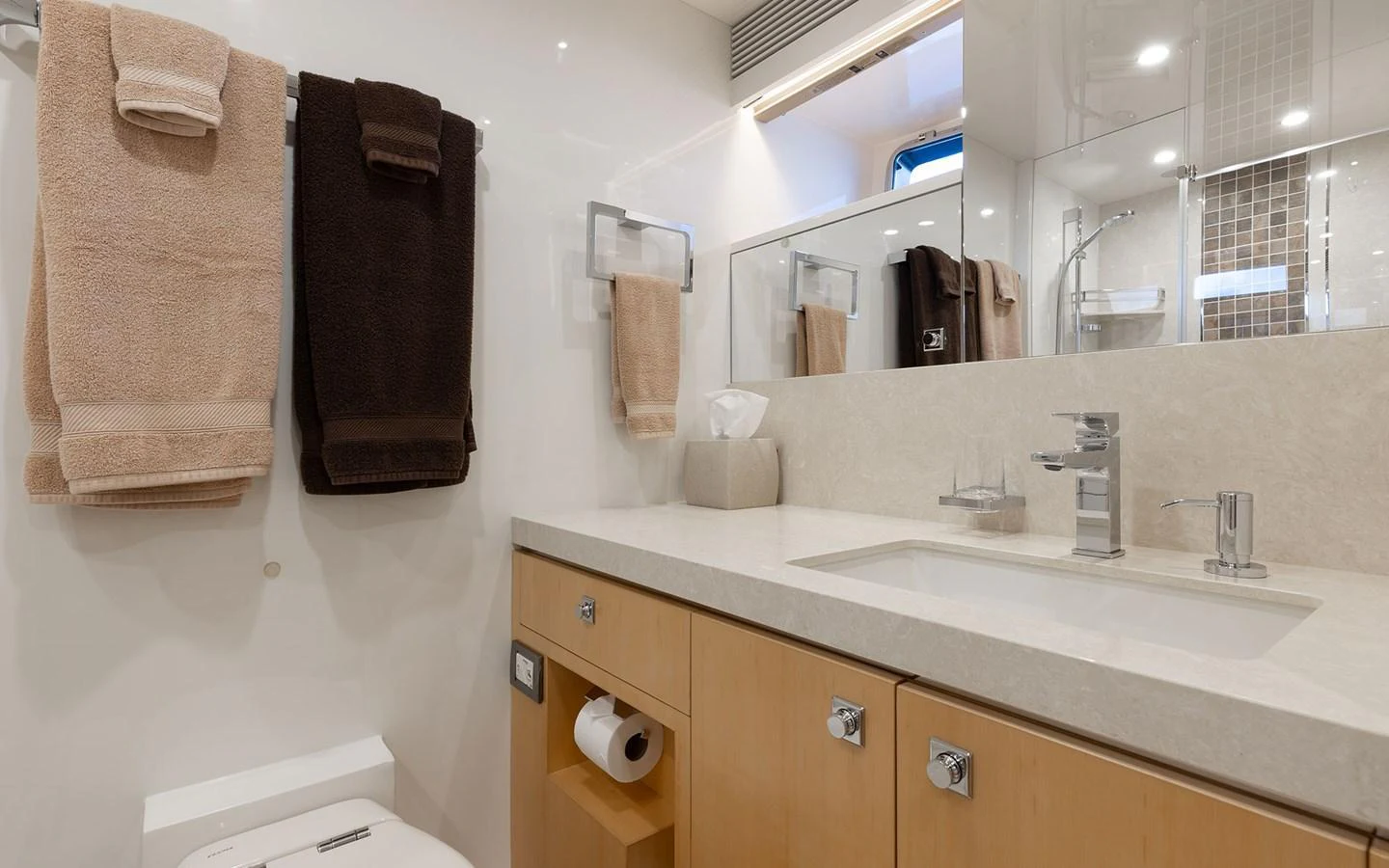 The yacht's bathroom features a modern sink, ample storage, and luxurious towels. aboard WADDLE WE DO Yacht for Sale