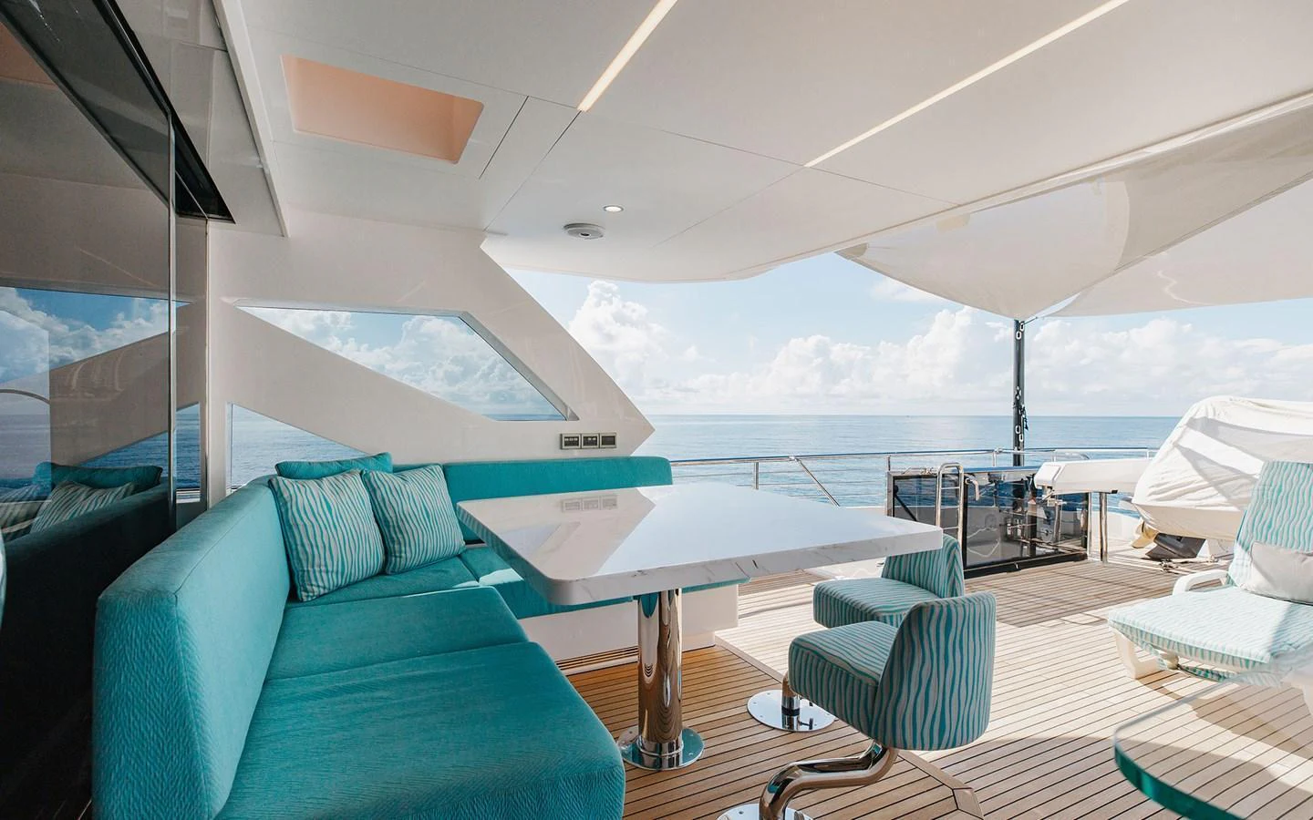 The aft deck features a stylish seating area with a large table, perfect for alfresco dining with stunning ocean views. aboard WADDLE WE DO Yacht for Sale