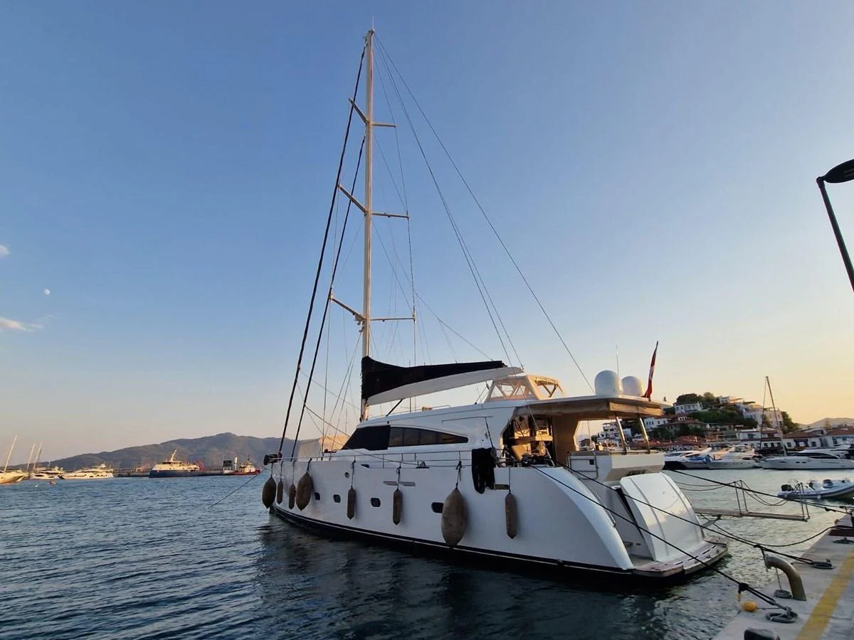 A sleek yacht is docked at a marina, showcasing its elegant design and spacious deck. aboard 23 M MOTORSAILOR Yacht for Sale