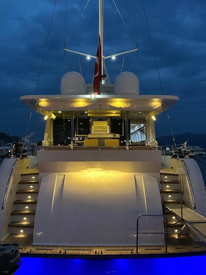 The yacht's aft deck is beautifully illuminated against a twilight sky, showcasing its elegant design and inviting ambiance. aboard 23 M MOTORSAILOR Yacht for Sale