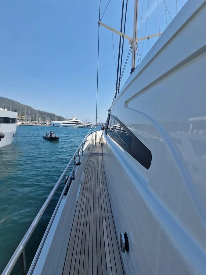 The side deck offers a sleek walkway with a view of the marina and other yachts. aboard 23 M MOTORSAILOR Yacht for Sale