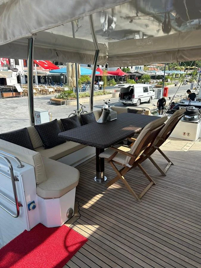 The aft deck features a comfortable dining area with cushioned seating and a table, perfect for alfresco meals. aboard 23 M MOTORSAILOR Yacht for Sale