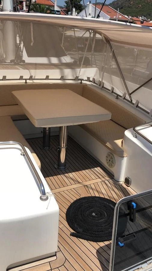 The aft deck features a cozy seating area with a table, perfect for outdoor dining and relaxation. aboard 23 M MOTORSAILOR Yacht for Sale
