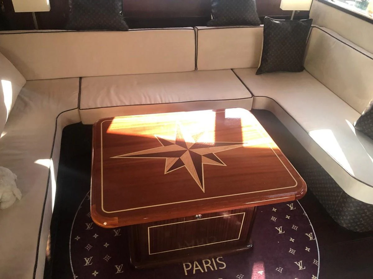 The salon features a stylish seating area with a custom wooden table and luxurious cushions. aboard 23 M MOTORSAILOR Yacht for Sale