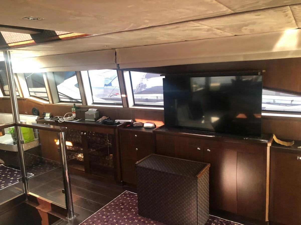 The yacht's interior features a cozy lounge area with a large television and ample natural light from the windows. aboard 23 M MOTORSAILOR Yacht for Sale