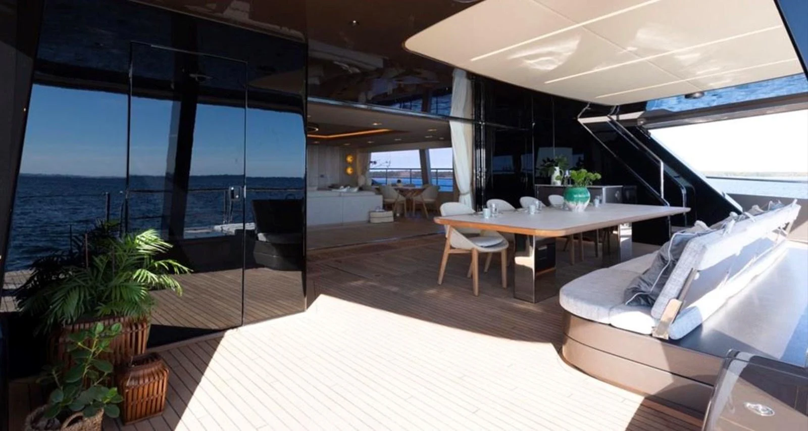 The aft deck features a spacious seating area with a dining table, seamlessly blending indoor and outdoor living. aboard TWILIGHT Yacht for Sale