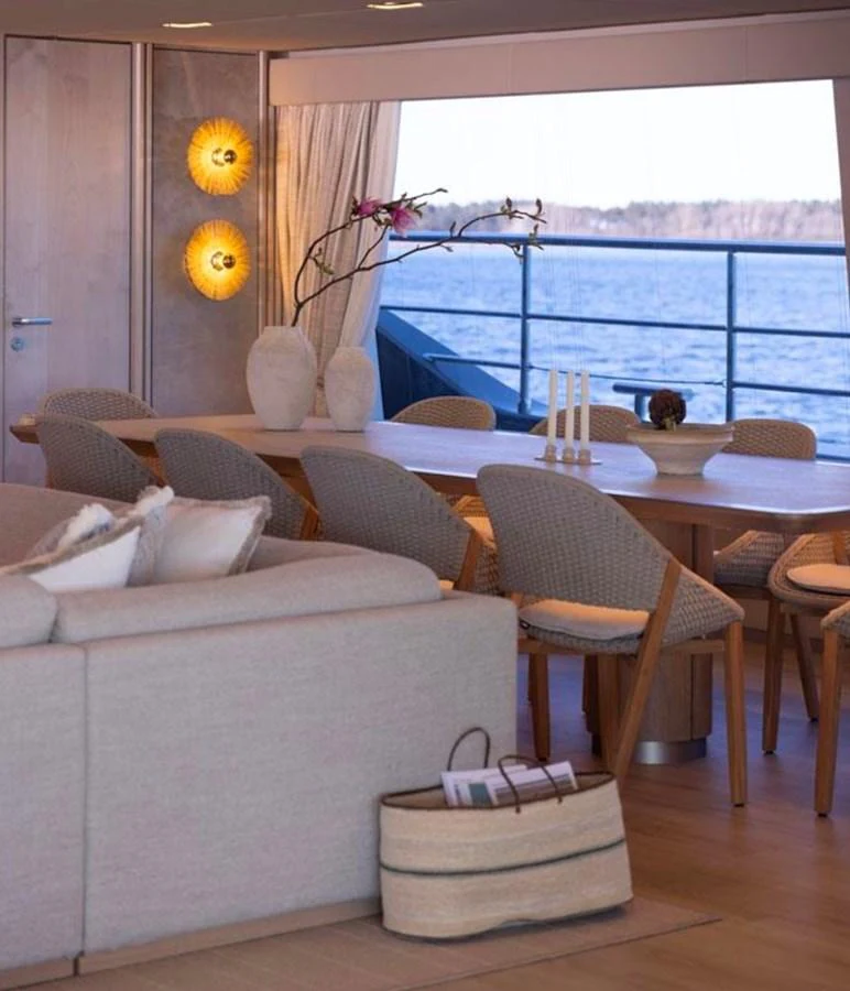 The salon features a cozy seating area and a dining table with a view of the water. aboard TWILIGHT Yacht for Sale