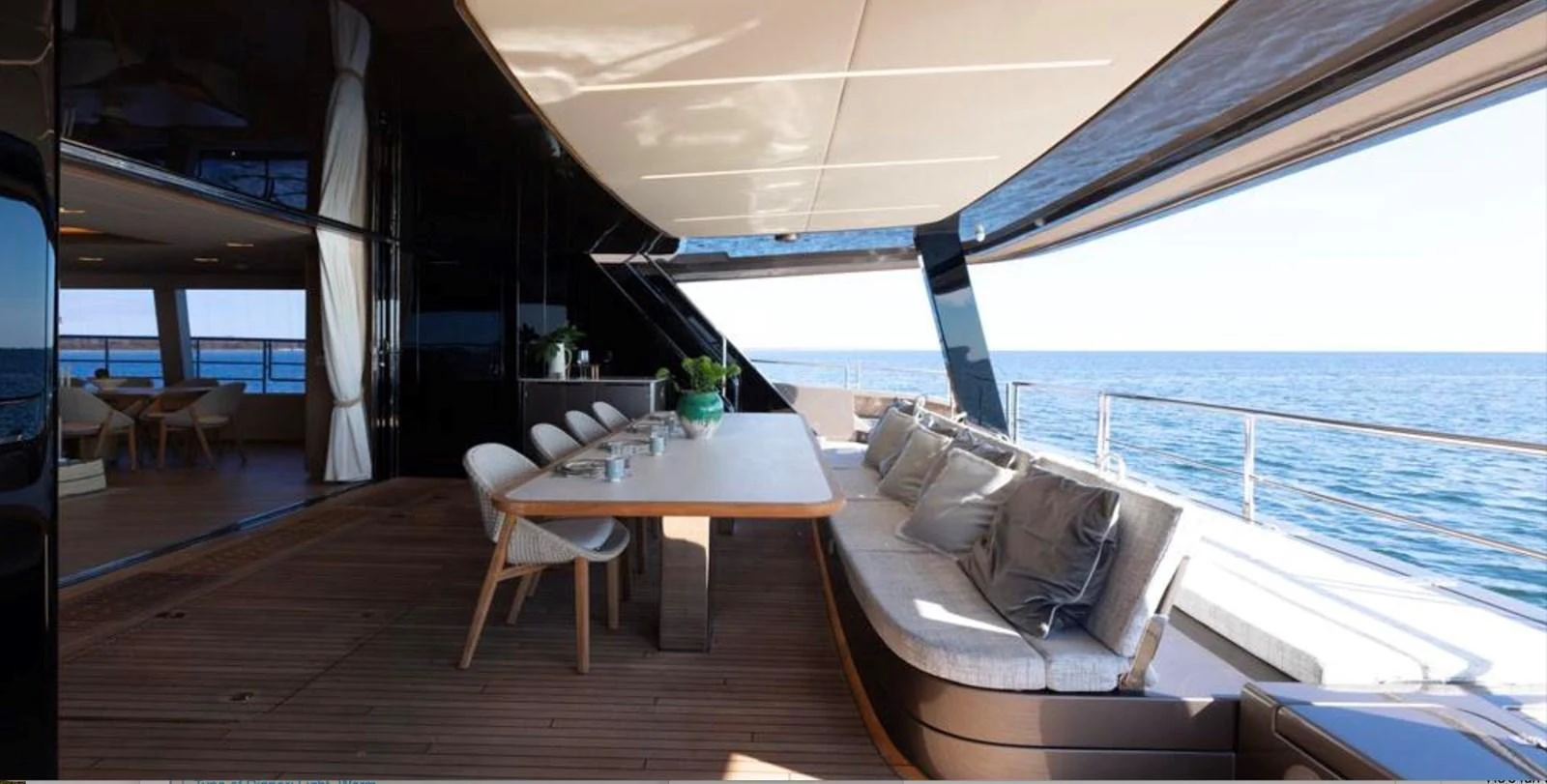 The aft deck features a spacious dining area with a large table and comfortable seating, perfect for alfresco meals with a stunning ocean view. aboard TWILIGHT Yacht for Sale