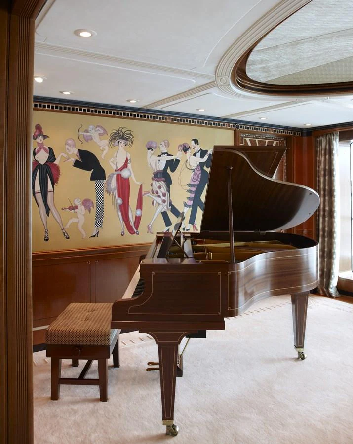 The salon features a grand piano and elegant wall art, creating a sophisticated ambiance. aboard LADY CHRISTINE Yacht for Sale