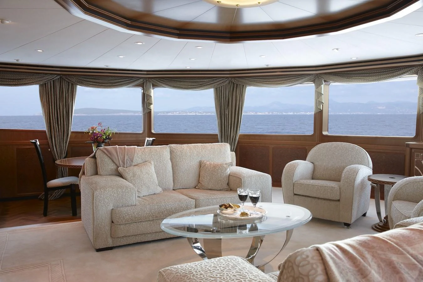 The salon offers a luxurious and comfortable seating area with panoramic ocean views. aboard LADY CHRISTINE Yacht for Sale