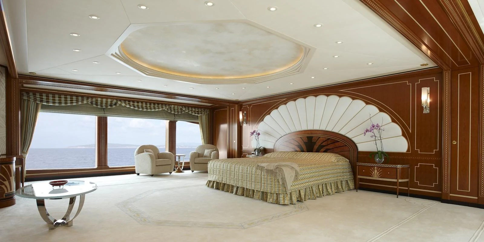 The master stateroom features elegant wood paneling, a large bed, and expansive windows with ocean views. aboard LADY CHRISTINE Yacht for Sale