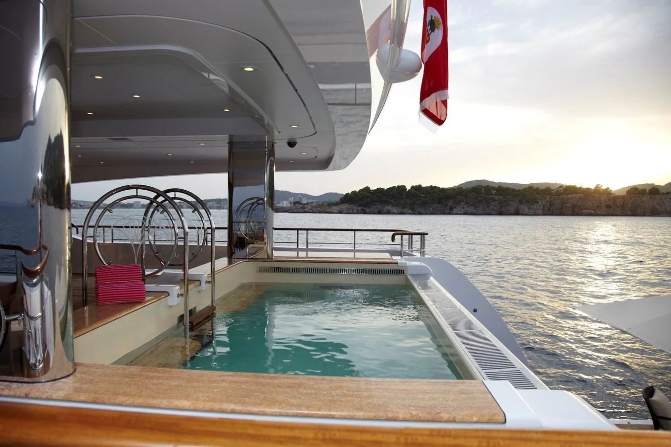 A luxurious pool deck on a yacht, offering stunning views of the water and surrounding landscape. aboard LADY CHRISTINE Yacht for Sale