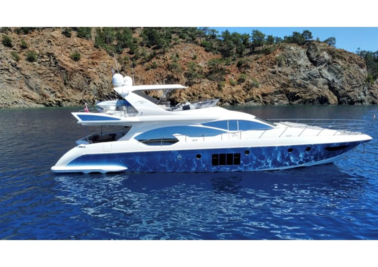 A sleek and modern yacht cruising along a rocky coastline in calm blue waters. aboard NE SEL Yacht for Sale