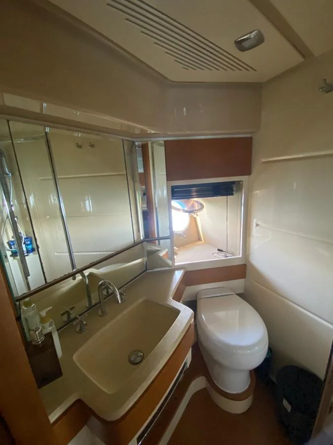 The yacht's head features a compact and functional design with a sink, toilet, and mirrored cabinets. aboard NE SEL Yacht for Sale