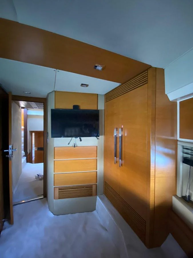 The yacht's interior features a modern entertainment area with a flat-screen TV and sleek wooden cabinetry. aboard NE SEL Yacht for Sale