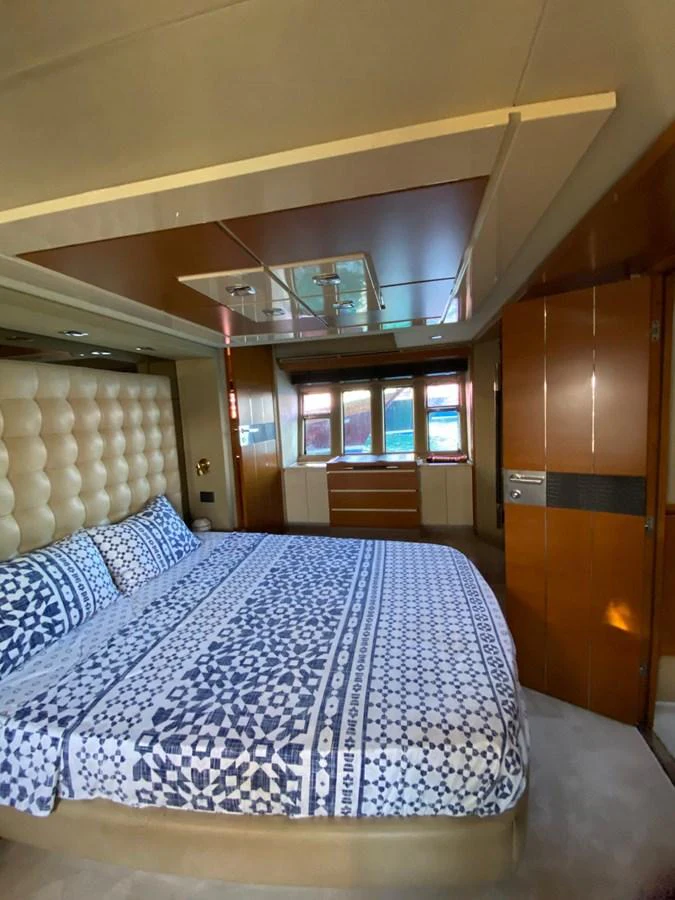 The stateroom features a plush bed with patterned linens and ample natural light from the windows. aboard NE SEL Yacht for Sale