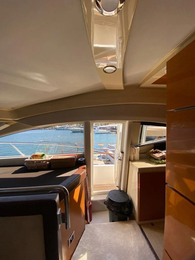 The interior view showcases a cozy area with a glimpse of the exterior marina through the window. aboard NE SEL Yacht for Sale