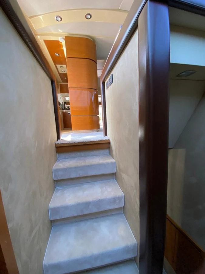 A cozy stairway with soft carpeting leads to the upper deck of the yacht. aboard NE SEL Yacht for Sale
