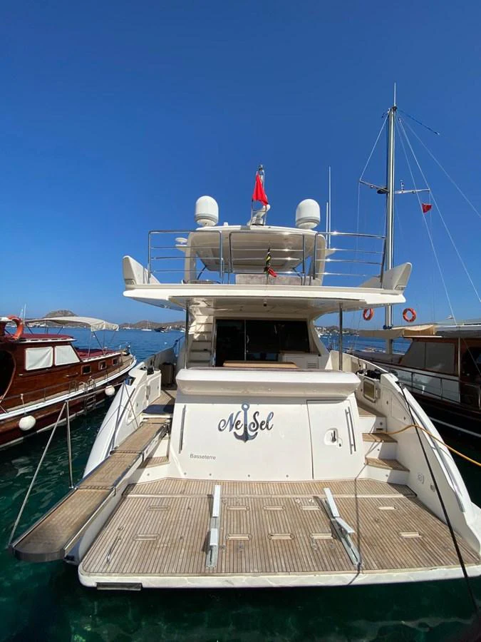 The yacht's aft deck is showcased, featuring a spacious layout with a clear view of the surrounding marina. aboard NE SEL Yacht for Sale