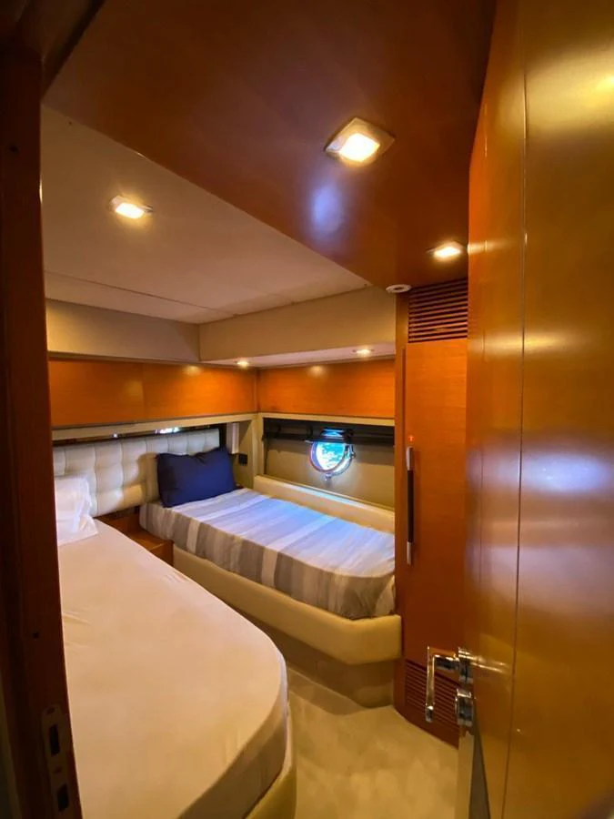 The guest stateroom offers cozy twin beds with warm wood finishes and soft lighting. aboard NE SEL Yacht for Sale