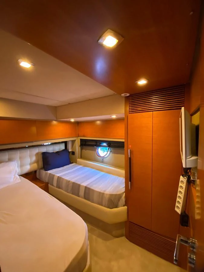 The guest cabin features cozy twin beds with warm wood finishes and soft lighting. aboard NE SEL Yacht for Sale