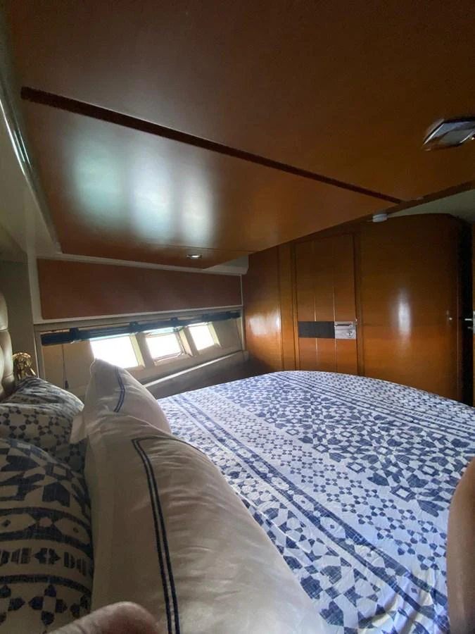 A cozy stateroom featuring a comfortable bed with patterned bedding and wooden accents. aboard NE SEL Yacht for Sale