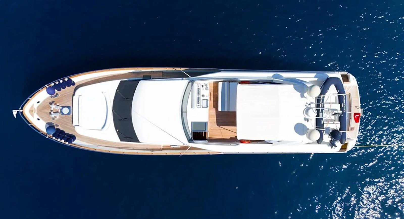 An aerial view of a sleek yacht cruising on deep blue waters. aboard TWINS PC Yacht for Sale
