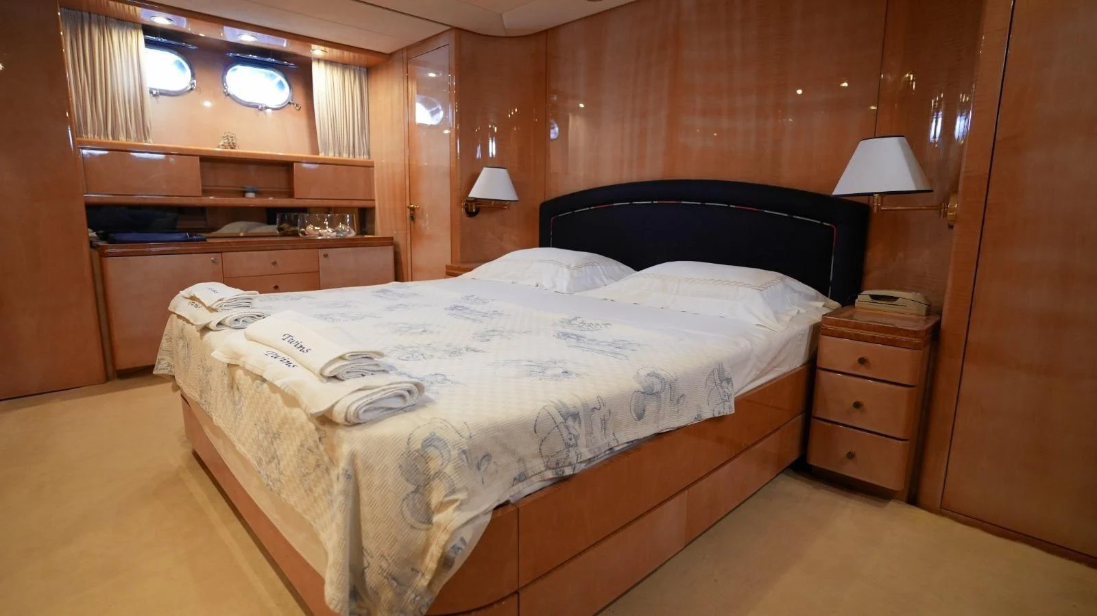 The stateroom features a luxurious double bed with elegant wood paneling and ample storage space. aboard TWINS PC Yacht for Sale