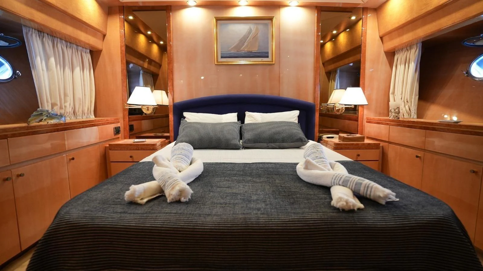 The master stateroom features a luxurious bed with elegant lighting and ample storage. aboard TWINS PC Yacht for Sale