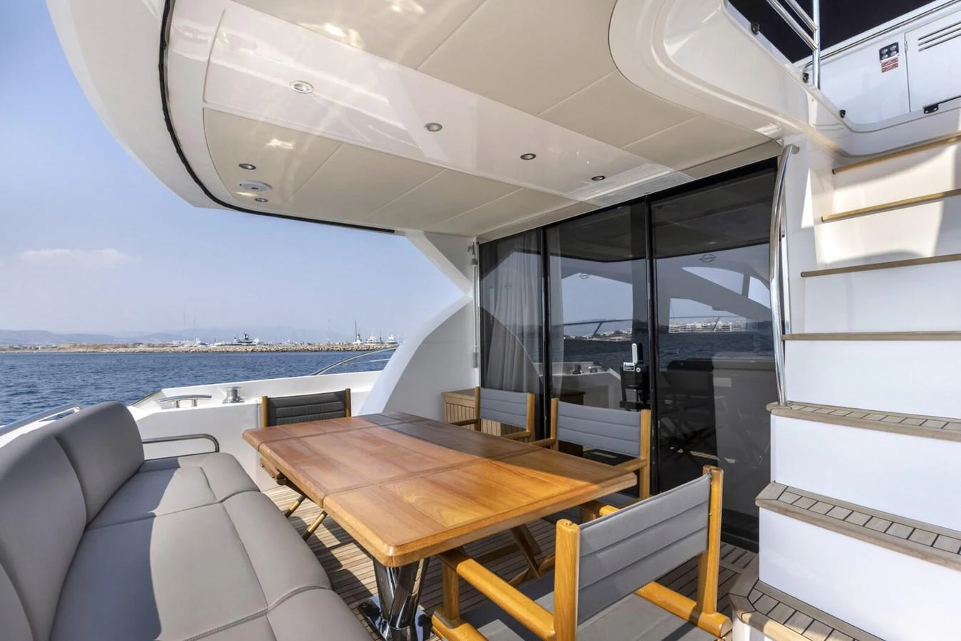The aft deck features a spacious dining area with a wooden table and comfortable seating, perfect for alfresco meals. aboard "CORAZON DE LEON" Yacht for Sale