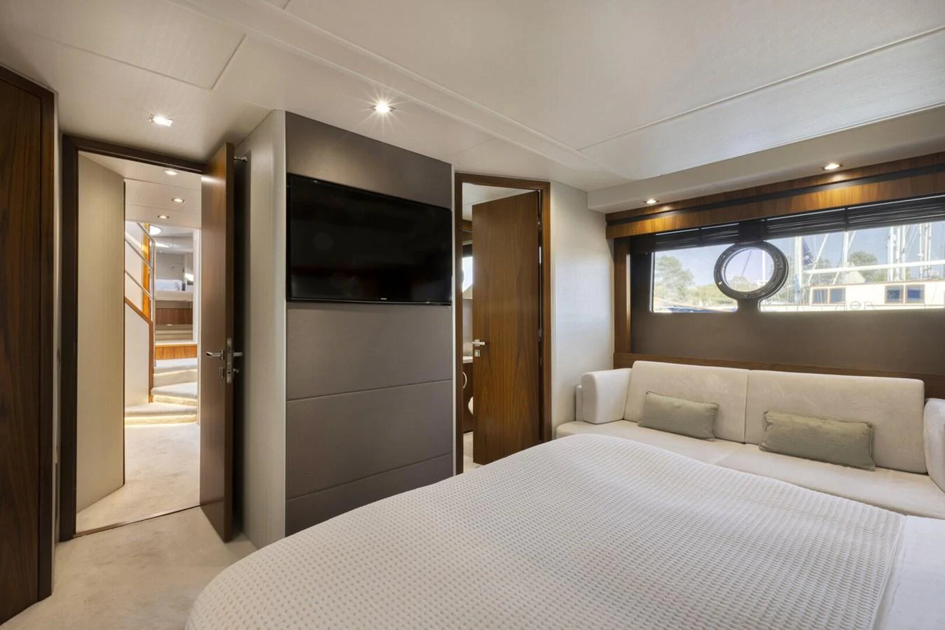The stateroom features a plush bed, a wall-mounted TV, and elegant wood accents. aboard "CORAZON DE LEON" Yacht for Sale