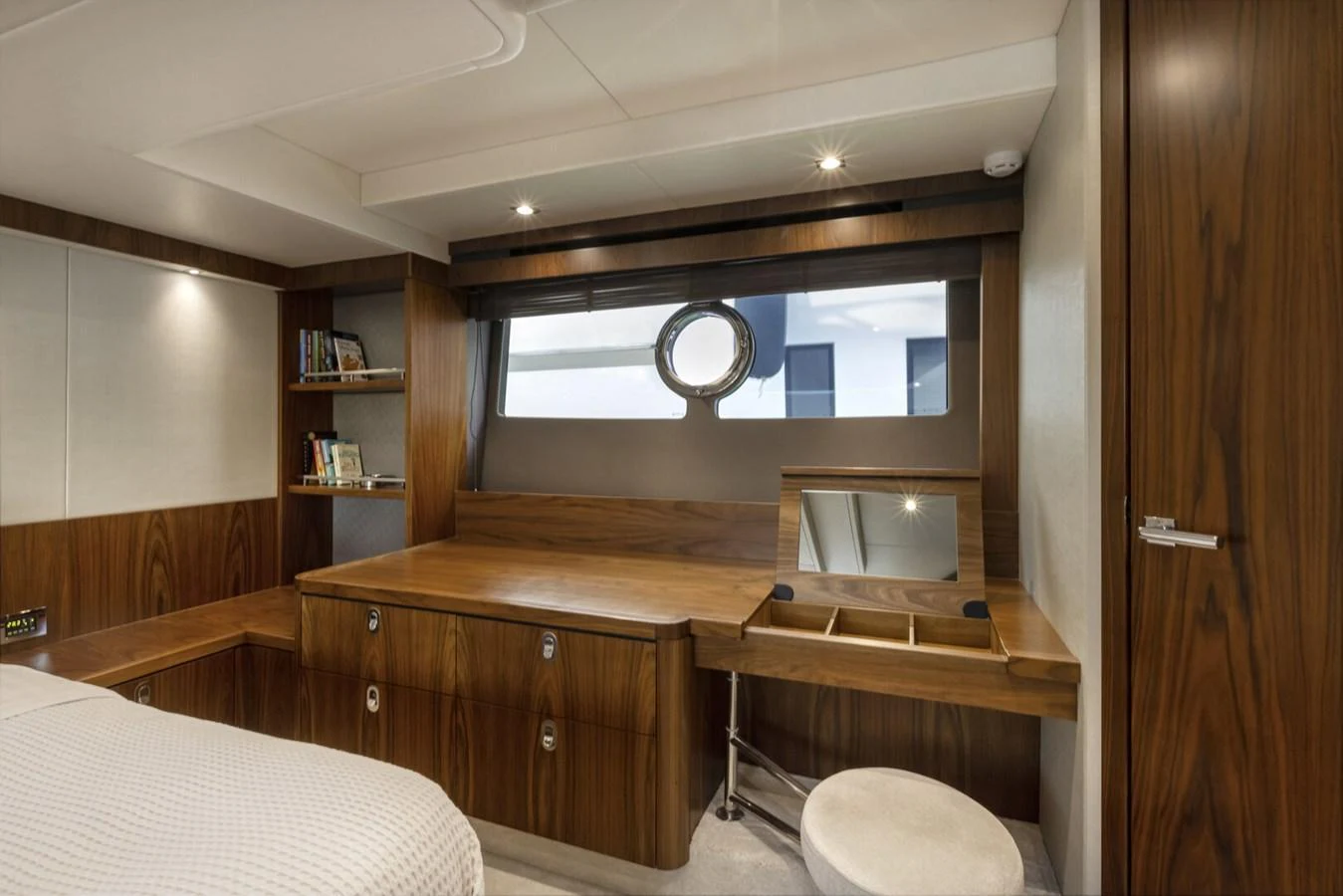 The stateroom features a sleek wooden desk area with a porthole window, creating a cozy and functional space. aboard "CORAZON DE LEON" Yacht for Sale