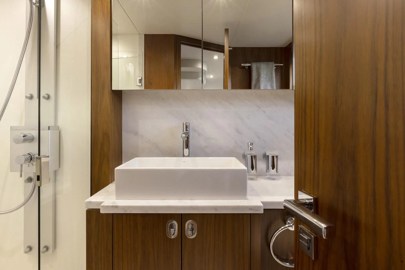 The yacht's bathroom features a sleek, modern design with a vessel sink and elegant wood cabinetry. aboard "CORAZON DE LEON" Yacht for Sale