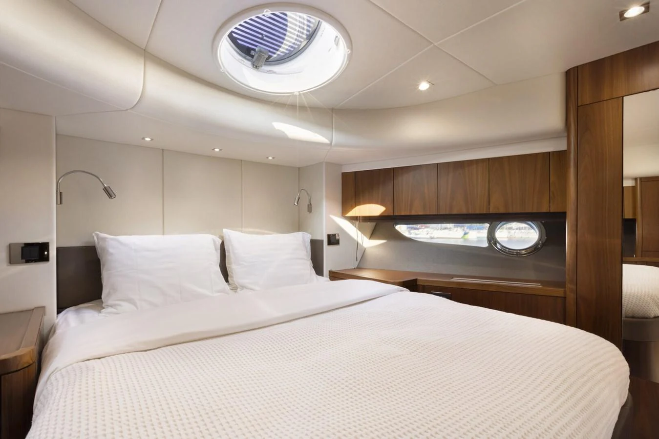 The stateroom features a plush bed with elegant wood accents and ample natural light. aboard "CORAZON DE LEON" Yacht for Sale