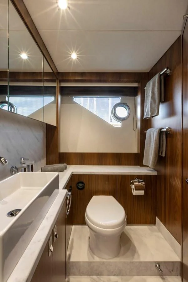 The yacht's bathroom features modern fixtures and a sleek design with wood accents. aboard "CORAZON DE LEON" Yacht for Sale