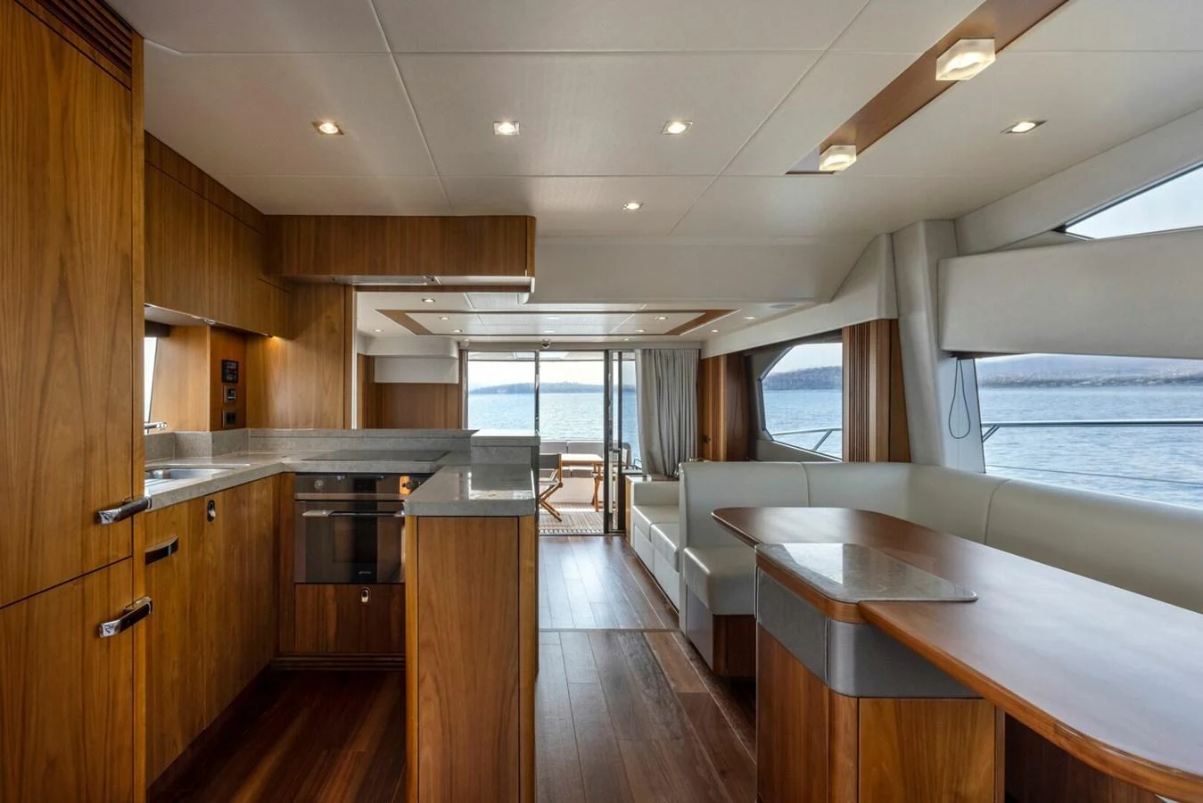The yacht's galley features modern wood cabinetry and sleek countertops, offering a spacious and stylish cooking area with a view of the sea. aboard "CORAZON DE LEON" Yacht for Sale