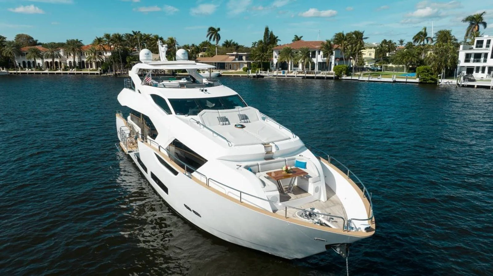 A luxurious yacht cruising in a serene waterfront setting with elegant residential backdrops. aboard 95 FT 2018 SUNSEEKER 95 YACHT, MIRRACLE Yacht for Sale