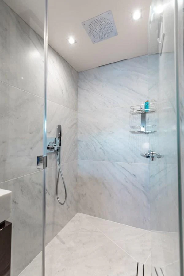 The yacht's bathroom features a sleek, modern design with marble walls and a glass shower enclosure. aboard 95 FT 2018 SUNSEEKER 95 YACHT, MIRRACLE Yacht for Sale