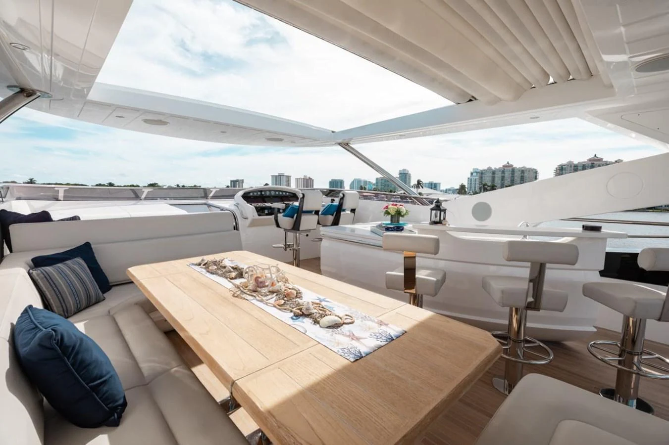 The flybridge offers a spacious and luxurious seating area with a dining table and bar stools, perfect for entertaining. aboard 95 FT 2018 SUNSEEKER 95 YACHT, MIRRACLE Yacht for Sale