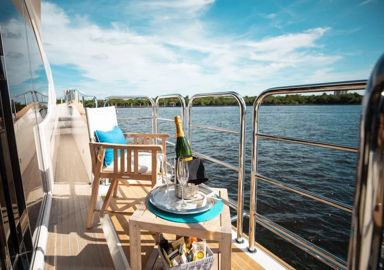 The yacht's deck features a cozy seating area with a table set for a luxurious outdoor experience. aboard 95 FT 2018 SUNSEEKER 95 YACHT, MIRRACLE Yacht for Sale