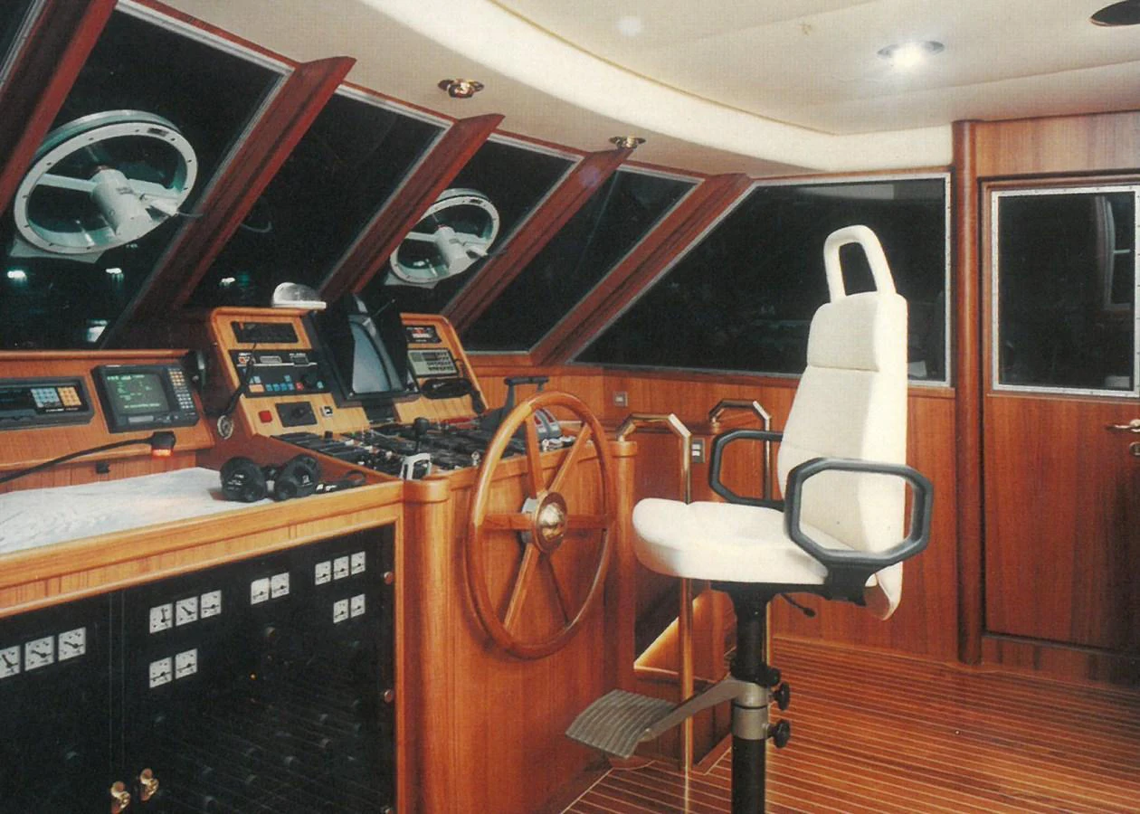 The helm station features a classic wooden steering wheel and modern navigation equipment, providing a blend of tradition and technology. aboard REX AQUILA Yacht for Sale