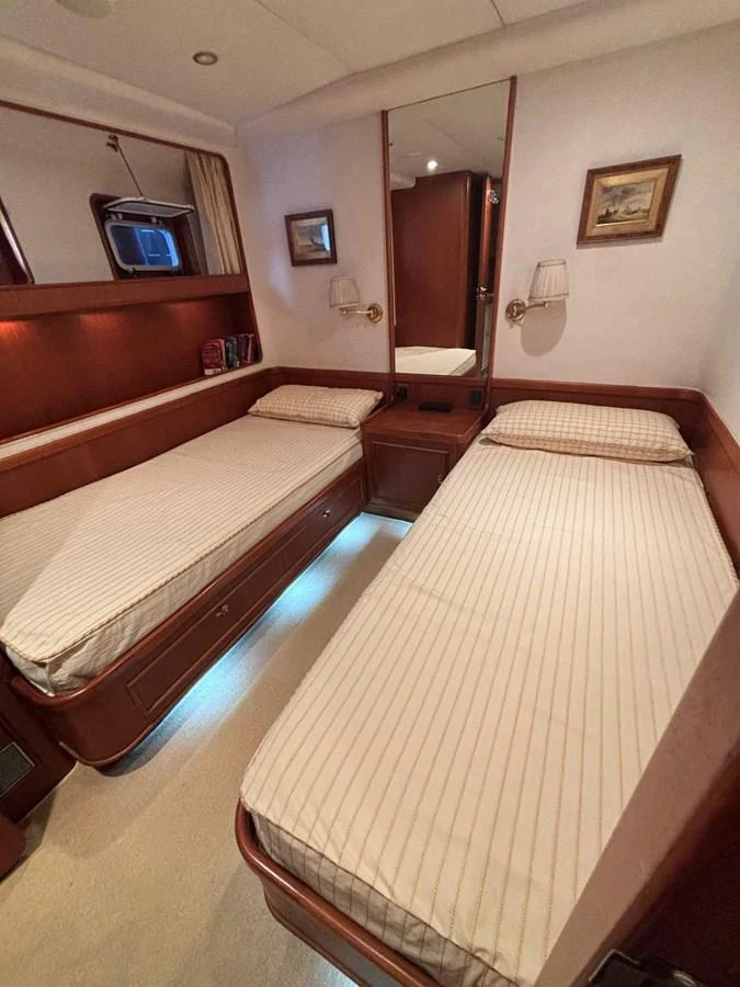 The twin cabin features two single beds with elegant wood paneling and soft lighting. aboard REX AQUILA Yacht for Sale