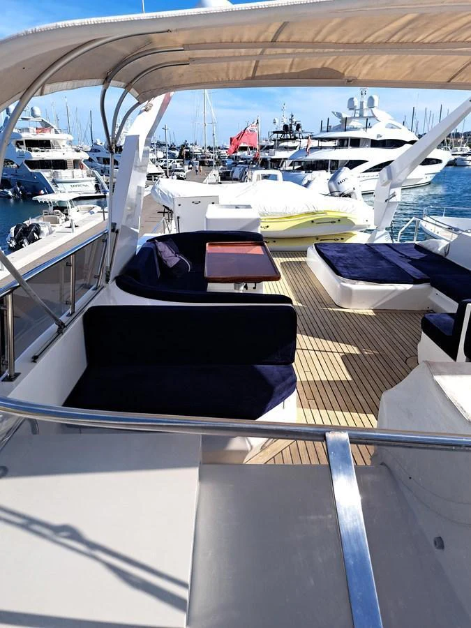 The flybridge features comfortable seating with a shaded area, perfect for enjoying the view at the marina. aboard REX AQUILA Yacht for Sale