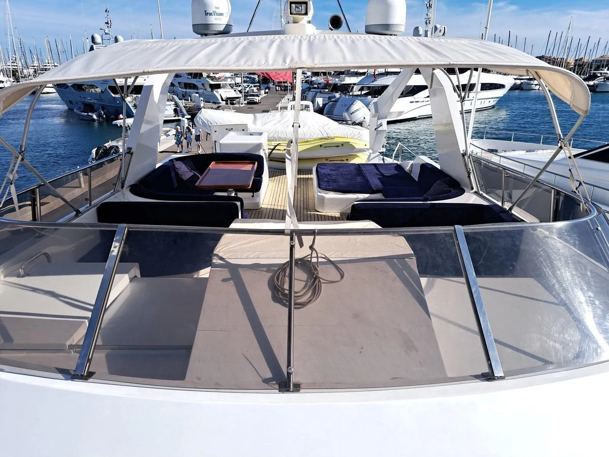The flybridge offers a spacious and inviting area for relaxation with comfortable seating and a shaded canopy. aboard REX AQUILA Yacht for Sale