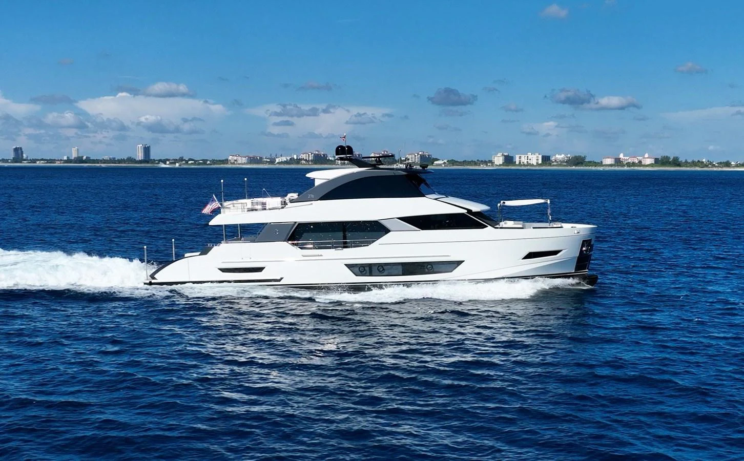 A sleek, modern yacht cruises smoothly on a clear blue sea under a bright sky. aboard AQUASITION Yacht for Sale