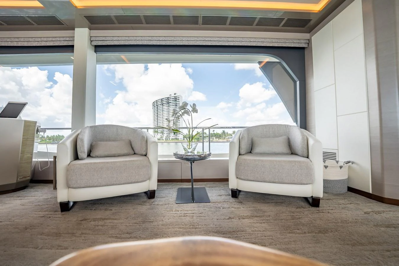 The yacht's interior features a serene seating area with large windows offering a stunning view. aboard AQUASITION Yacht for Sale