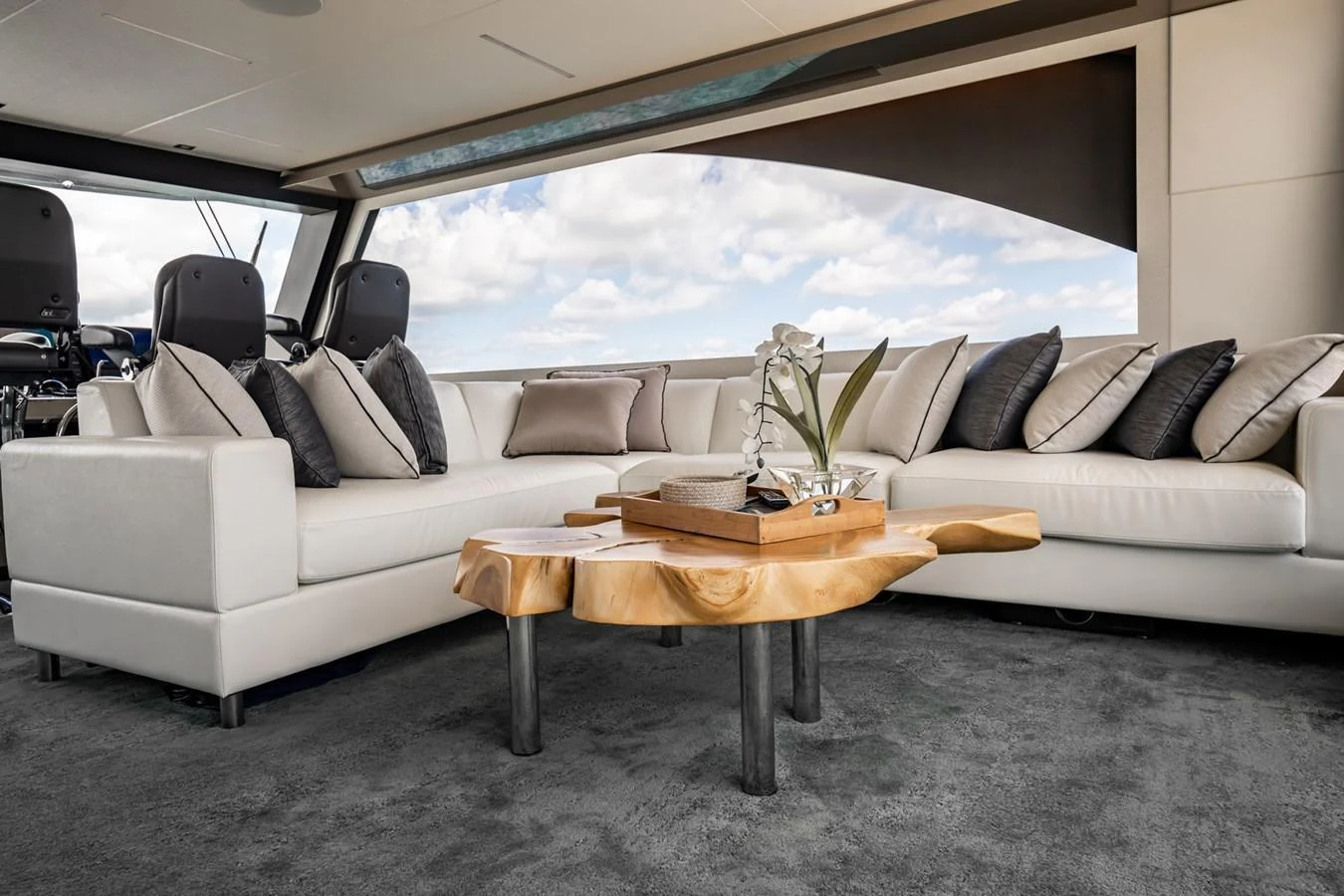 The salon features a luxurious seating area with plush white sofas and a unique wooden coffee table, offering a comfortable and stylish space for relaxation. aboard AQUASITION Yacht for Sale
