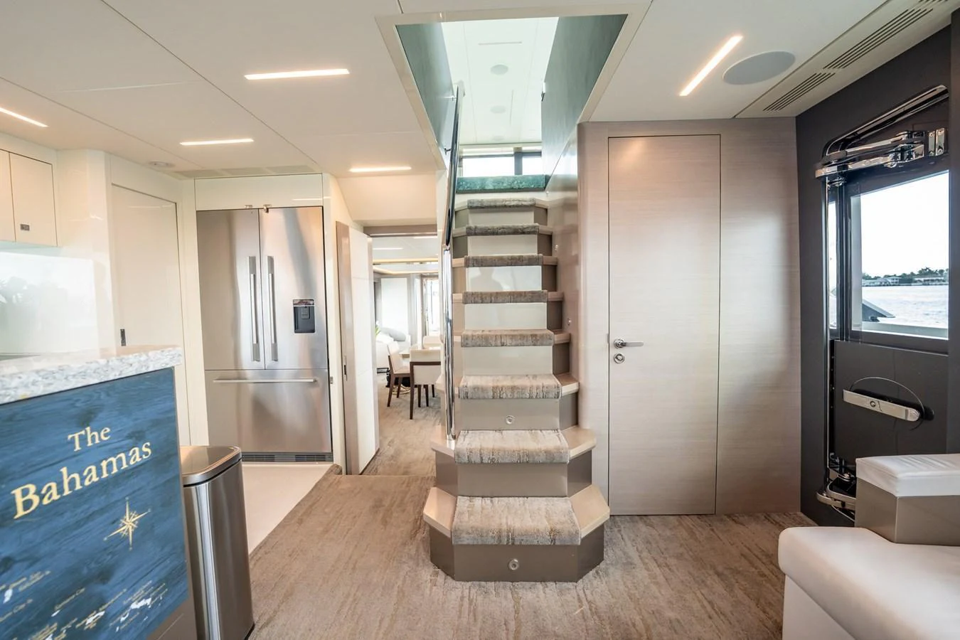 The main salon features a modern staircase and a view of the galley and stateroom. aboard AQUASITION Yacht for Sale