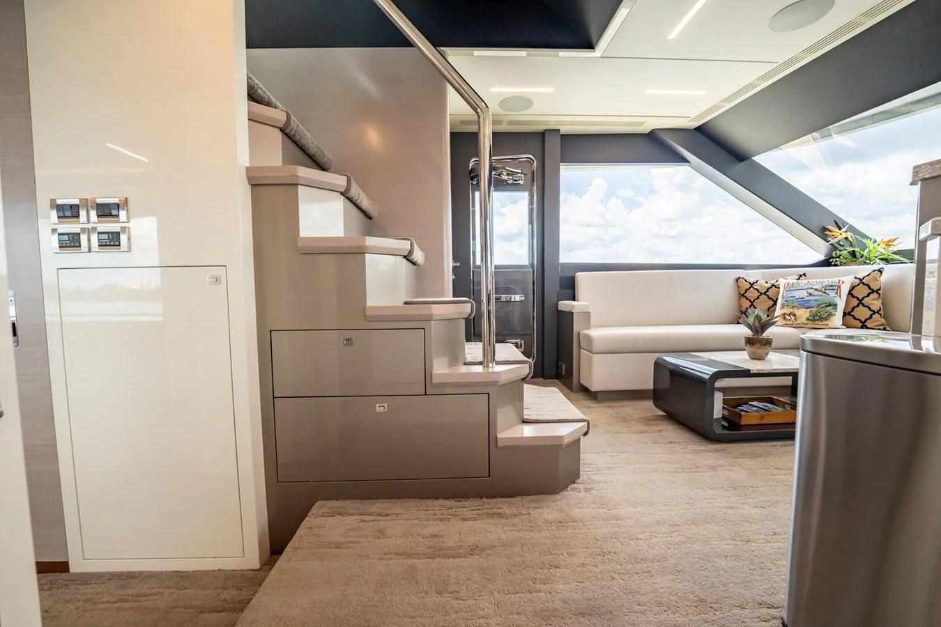 The salon features a modern staircase, plush seating, and large windows offering panoramic views. aboard AQUASITION Yacht for Sale