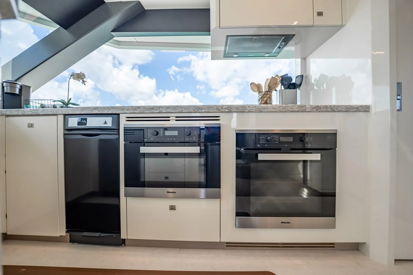 The modern galley is equipped with high-end appliances and offers a bright, airy atmosphere with a view of the sky. aboard AQUASITION Yacht for Sale